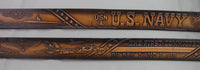 A brown leather belt with embossed US Navy symbols, including a submarine, aircraft, and the USN anchor emblem, with text 'U.S. NAVY' and 'BY SEA LAND & AIR