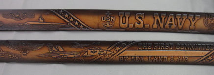 A brown leather belt with embossed US Navy symbols, including a submarine, aircraft, and the USN anchor emblem, with text 'U.S. NAVY' and 'BY SEA LAND & AIR
