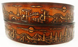 A leather belt with an oil fields scene continuous from one end to the other, featuring a dark edge and a beautifully blended brown center, with a buckle on one end.